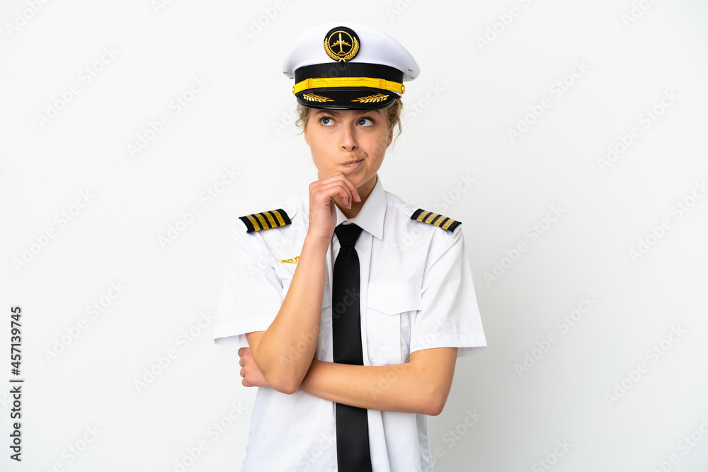 Airplane blonde woman pilot isolated on white background having doubts and thinking Airplane blonde woman pilot isolated on white background having doubts and thinking
