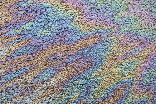 Oil spill pattern on wet asphalt. Abstract colorful background image.