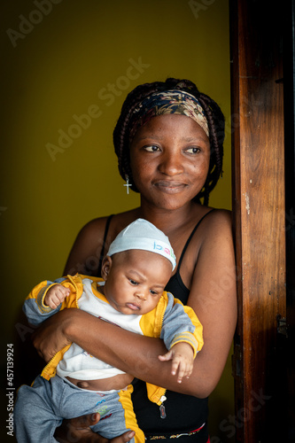 African American young mother holding her baby indoors