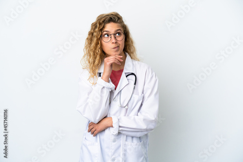 Young doctor blonde woman isolated on white background and looking up