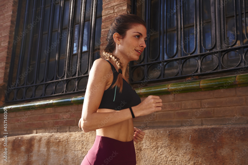 Obraz premium Woman jogging past a steel framed window