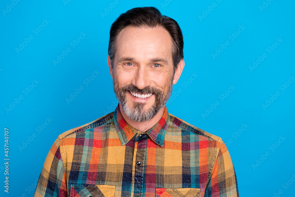 Photo of nice brunet hairdo mature man wear yellow shirt isolated on blue color background Photo of nice brunet hairdo mature man wear yellow shirt isolated on blue color background