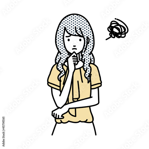 立って手をあごにあてて困っているオフィスカジュアルの女性
