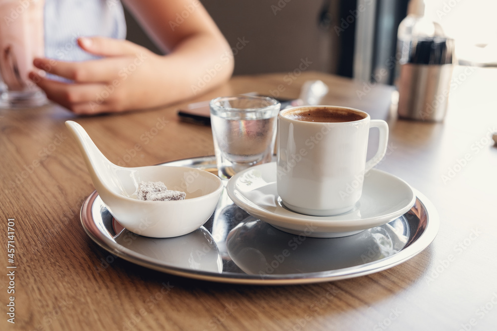 Traditional Turkish coffee with cold water and Turkish delight in cafe. Selective focus Traditional Turkish coffee with cold water and Turkish delight in cafe. Selective focus