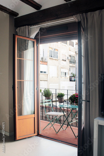 small balcony tastefully decorated chairs table and plants