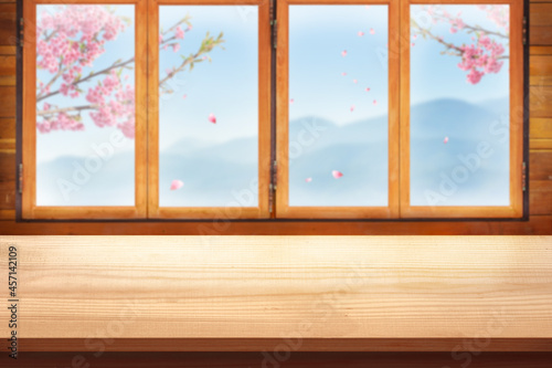 Blank Wooden table top with wood window and mountain view and sakura flower branch display for product concept