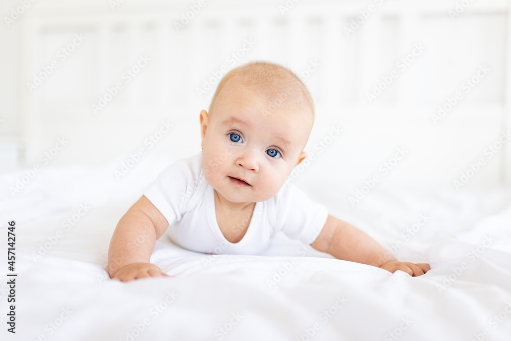 Portrait of cute and smiling four month old baby girl playing on the bed in her room. Happy and dry kid. Portrait of cute and smiling four month old baby girl playing on the bed in her room. Happy and dry kid.