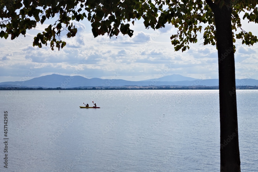 Two girls are canoeing on the Trasimeno lake (Umbria, Italy, Europe)