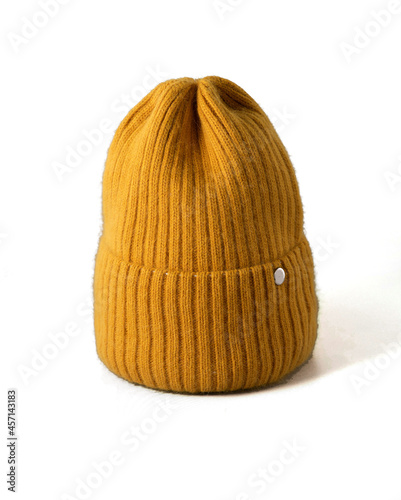 Small yellow knitted hat on white isolated background. woolly hat Closeup.