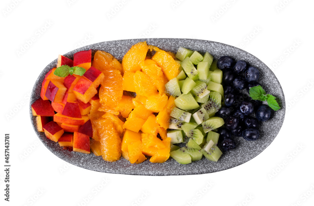 Assorted chopped fruits and berries in rows reminding rainbow colors on the plate isolated on white. Nectarine, orange, mango, kiwi and blueberry Assorted chopped fruits and berries in rows reminding rainbow colors on the plate isolated on white. Nectarine, orange, mango, kiwi and blueberry