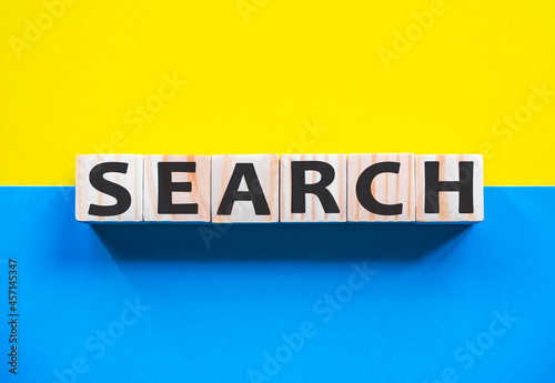 Word SEARCH on wooden cubes with word on beautiful yellow and blue background. Business, media marketing concept.