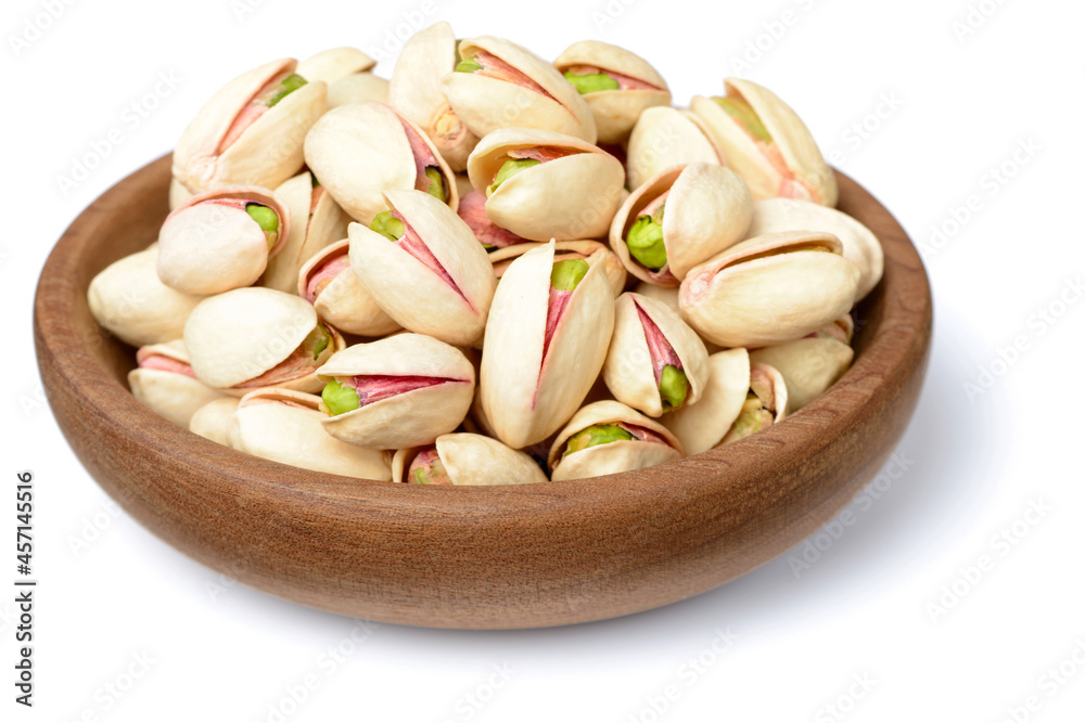 pistachios nuts in the wooden plate, isolated on white pistachios nuts in the wooden plate, isolated on white