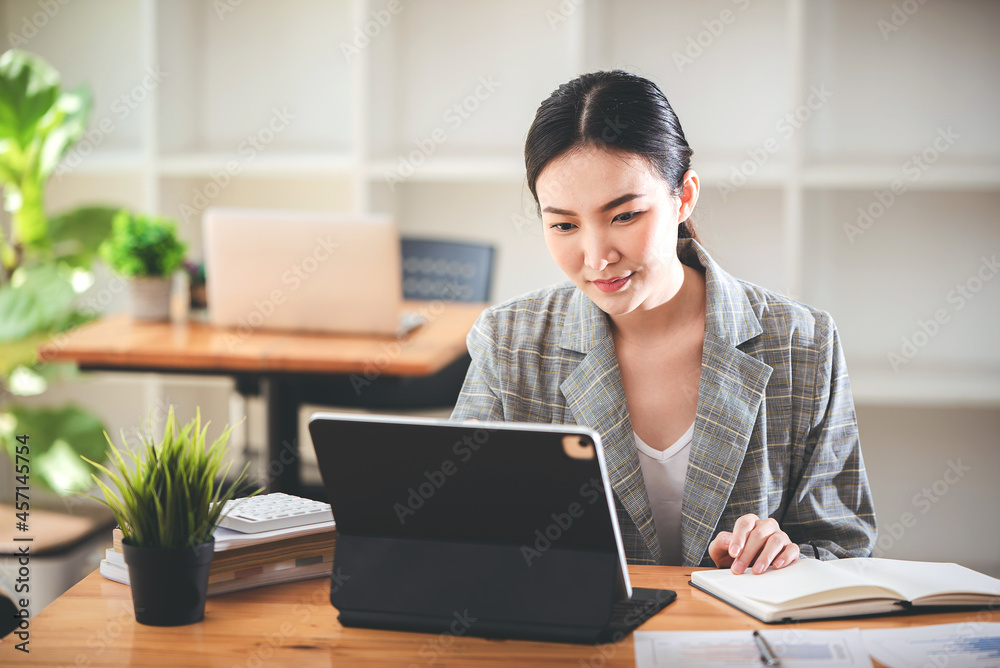 Asian girls are enjoying business video call, sitting at desk, using laptop computer, having video chat, waving Asian girls are enjoying business video call, sitting at desk, using laptop computer, having video chat, waving