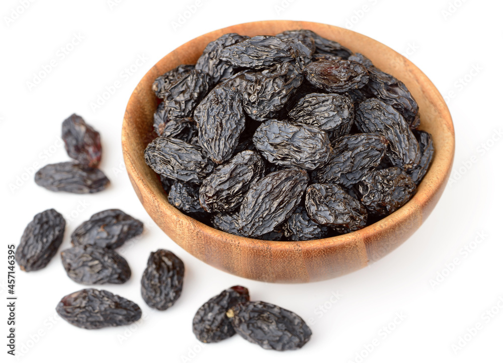 black raisins in the wooden bowl, isolated on white background black raisins in the wooden bowl, isolated on white background
