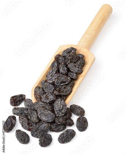 black raisins in the wooden scoop, isolated on white background