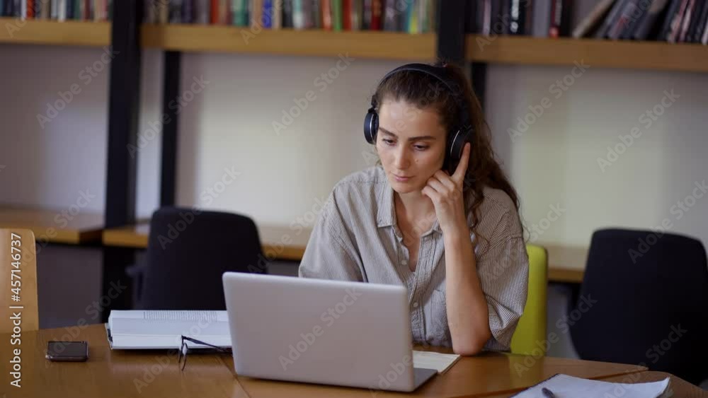 Young woman study at distant learning at library with laptop