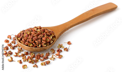 dried Szechuan pepper in the wooden spoon, isolated on the white background