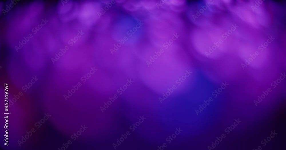Blue and purple bokeh abstract background. Tracking shot, moving left to right. 