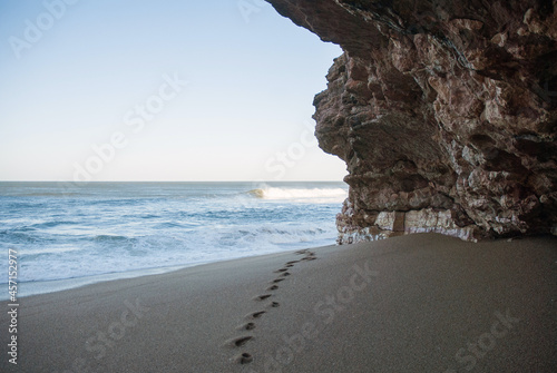 View of the sea from the beach grotto with footprints on the sand