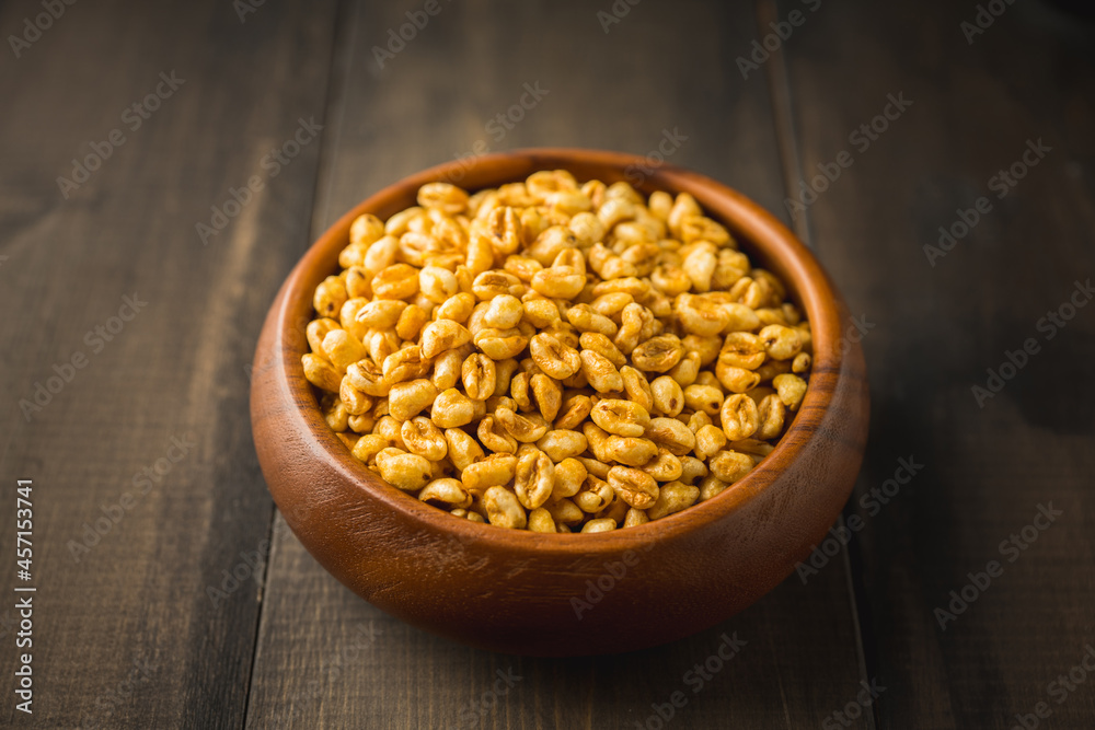 Wheat flakes cereal breakfast in wooden bowl on the rustic background. Selective focus.