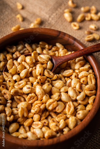 Wheat flakes cereal breakfast in wooden bowl on the rustic background. Selective focus.