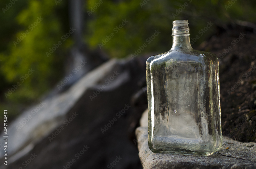 old clear bottle on nature background, parc régional seigneurie de la matapédia, québec, canada