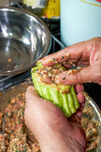 A chef is making a traditional Chinese dish from Guangxi, bitter gourd stuffed with meat
