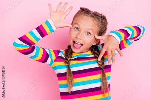 Photo of funky foolish little lady mocking bully hands temples wear striped shirt isolated pink color background