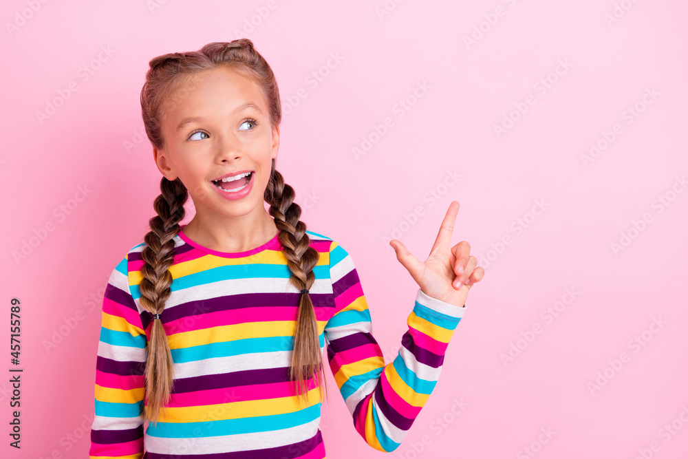 Photo of little lady indicate forefinger empty space look up wear striped shirt isolated pink color background Photo of little lady indicate forefinger empty space look up wear striped shirt isolated pink color background