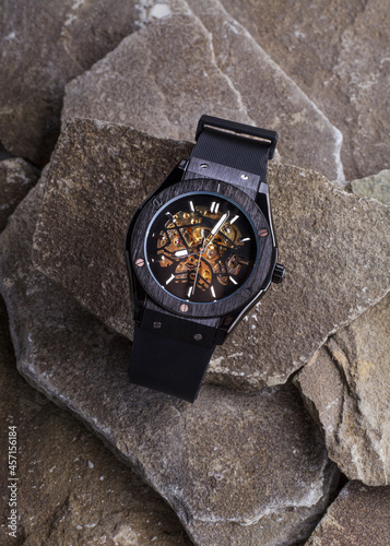 Fotografía black men's watches lie on a background of stones