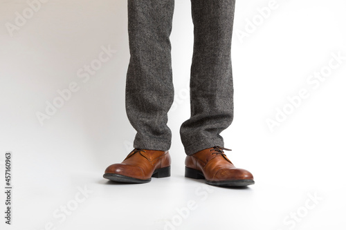 close up of Brown leather with man leg in black pants on white background.