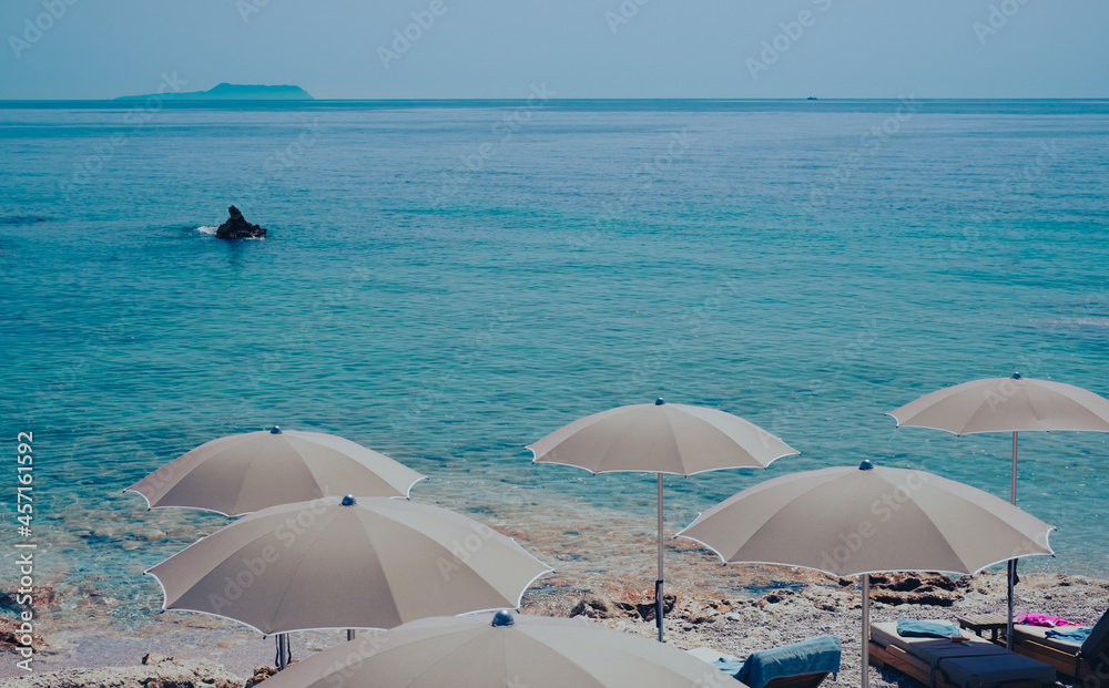 Tranquil view to Dhermi beach turquoise water and umbrellas. Summer holiday vacation travel destination in Albania