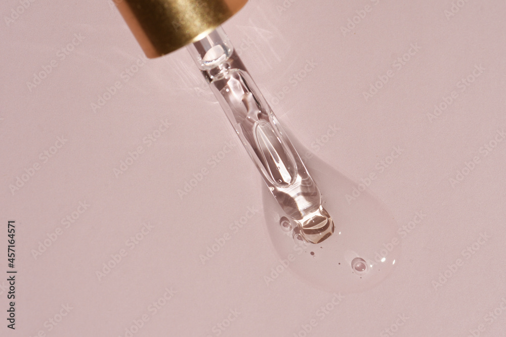 Liquid oil serum drop in pipette isolated on pastel pink background. Retinol, aha, bha acid, collagen skincare fluid, photo with shallow depth of field. Gold essence in dropper for beauty treatment Liquid oil serum drop in pipette isolated on pastel pink background. Retinol, aha, bha acid, collagen skincare fluid, photo with shallow depth of field. Gold essence in dropper for beauty treatment