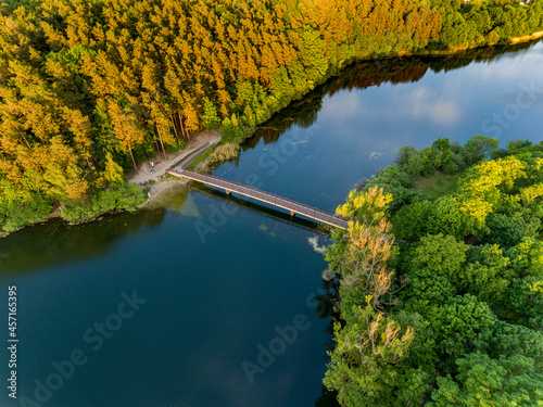 Olsztyn Lake Dlugie, bird's eye view. Wooded shores, the sky reflecting in the water table and a bridge over the lake - Warmia and Masuria, Poland photo