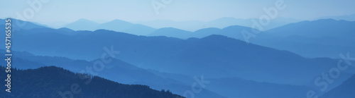 Fototapeta Naklejka Na Ścianę i Meble -  High peaks of blue mountain range landscape with fog and forest. Ukraine, Carpathians. Horizontal image.
