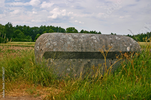 Stojący pośród pól lekki betonowy polski schron bunkier