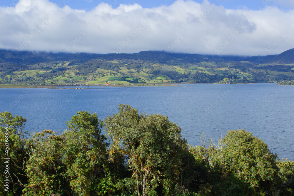 Blue lagoon with trees and clouds, colombian mountains, laguna de la cocha
