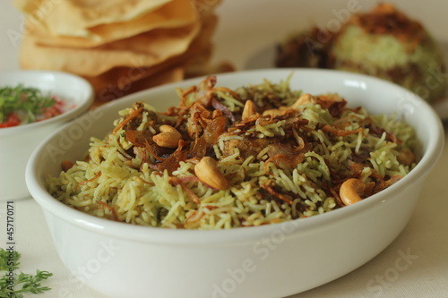Green Biriyani. It is made with boiling basmati rice with green coriander chutney paste and spices and then layered with curried chicken and caramelized onions