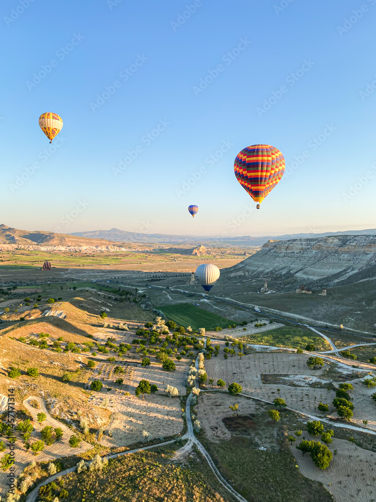Colorful balloons fly over Cappadocia, Turkey. Hot air balloon flight at sunrise.