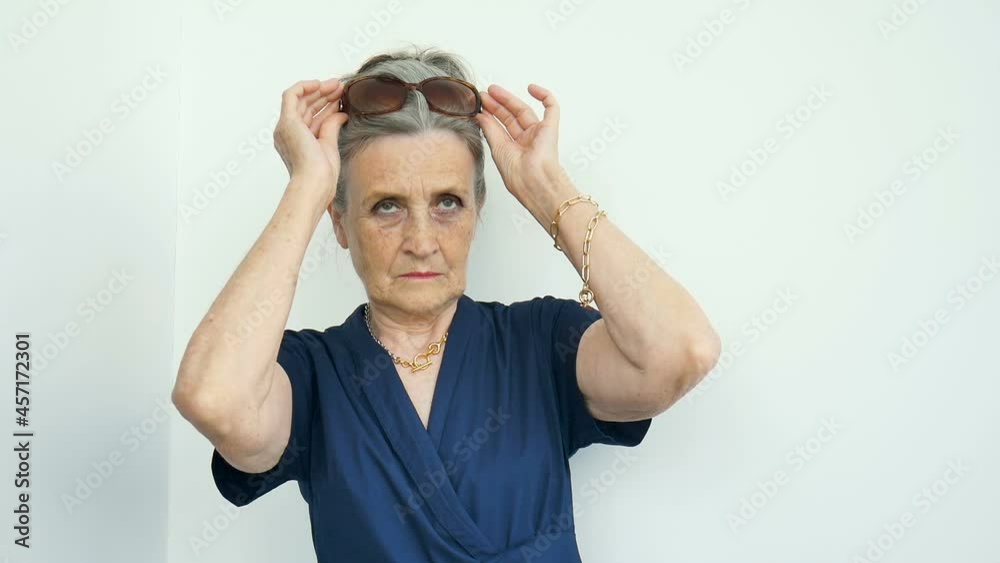 Female portrait of beautiful old grandmother with grey hair and face with wrinkles is grimacing while looking at the camera on white background, mothers day, happy retirement Female portrait of beautiful old grandmother with grey hair and face with wrinkles is grimacing while looking at the camera on white background, mothers day, happy retirement