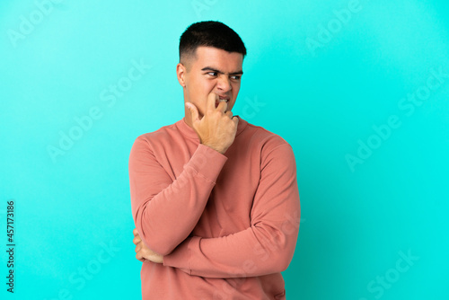 Young handsome man over isolated blue background nervous and scared