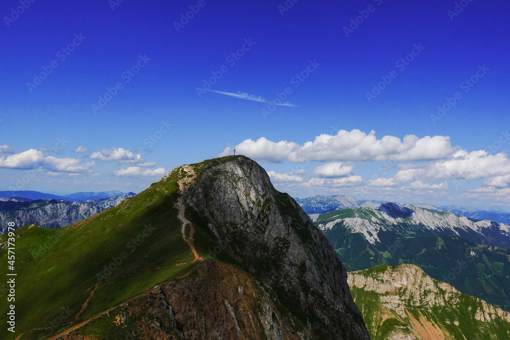 amazing steep mountain with a summit cross and wide view to other mountains with blue