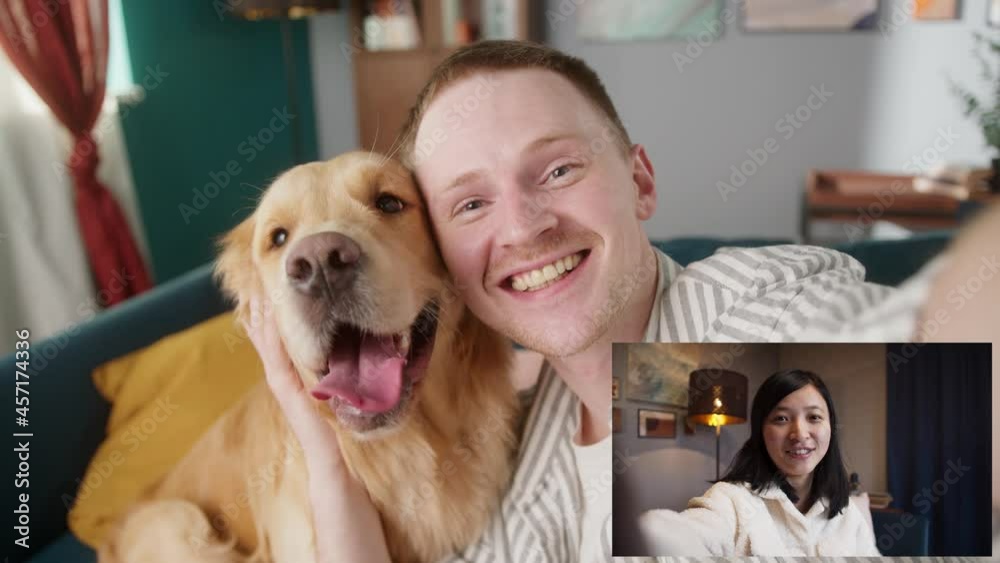 Happy man and golden retriever dog speaking with asian woman, lovely couple communicating online, using video call during coronavirus isolation. Smiling people talking via internet together with pet Happy man and golden retriever dog speaking with asian woman, lovely couple communicating online, using video call during coronavirus isolation. Smiling people talking via internet together with pet