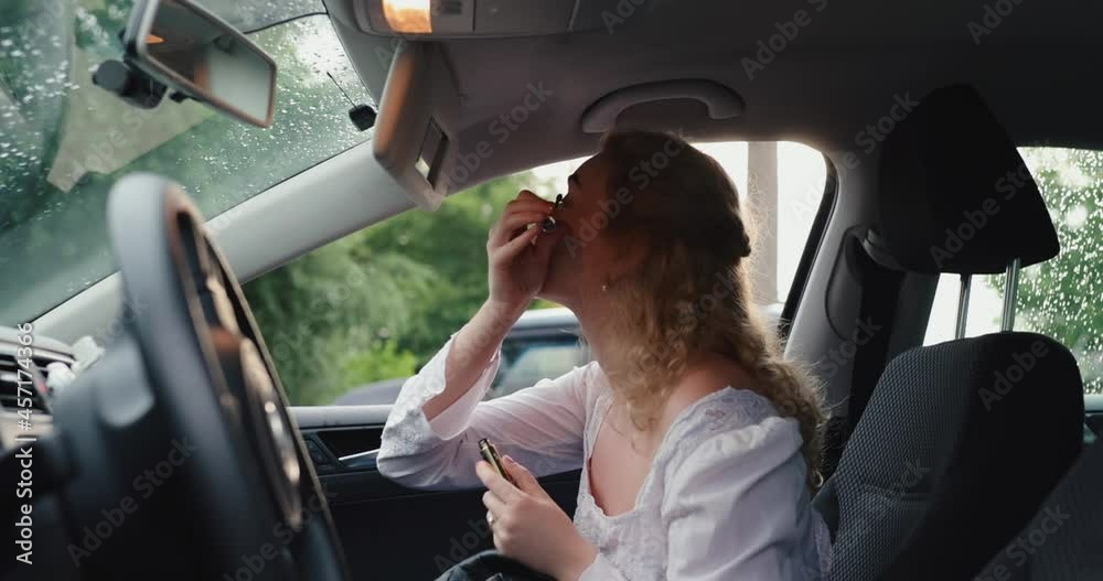 Girl paints eyelashes in the car with the mascara Girl paints eyelashes in the car with the mascara