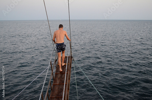 Man preparing to jump from the ship © Mariia