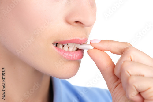 Woman putting chewing gum in her mouth with hand closeup