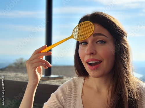 фотографія Caucasian woman with fly swatter looking for insects