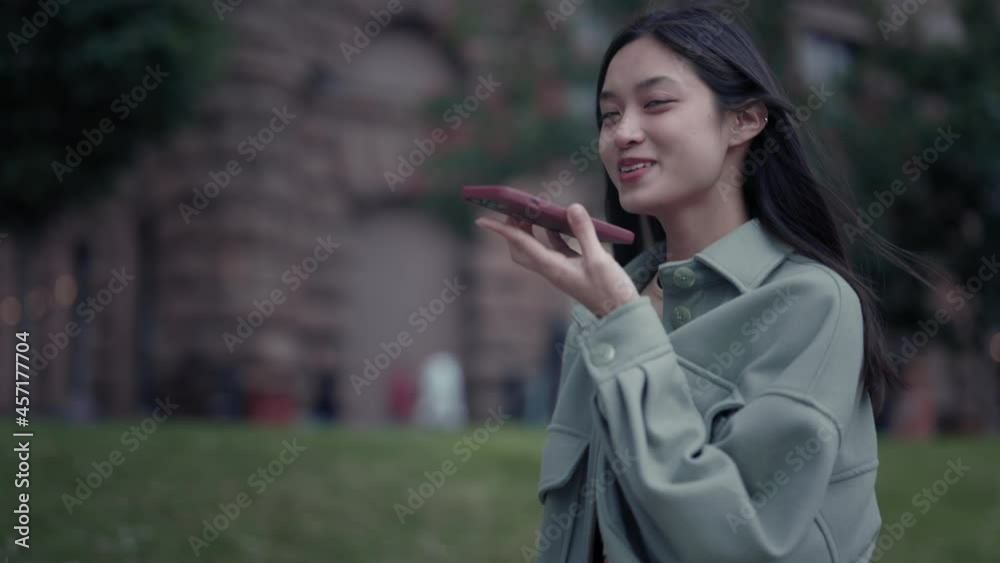 Korean woman using cell phone for recording voice message Korean woman using cell phone for recording voice message