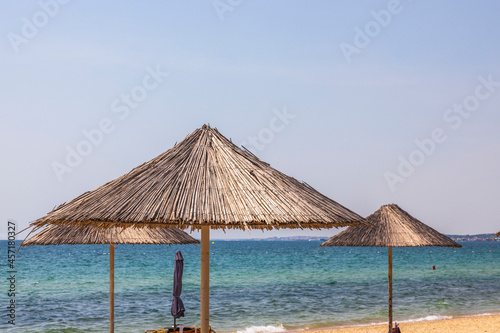 Fototapeta Naklejka Na Ścianę i Meble -  Beautiful view of white sand beach with sun umbrellas and sunbeds. Greece.
