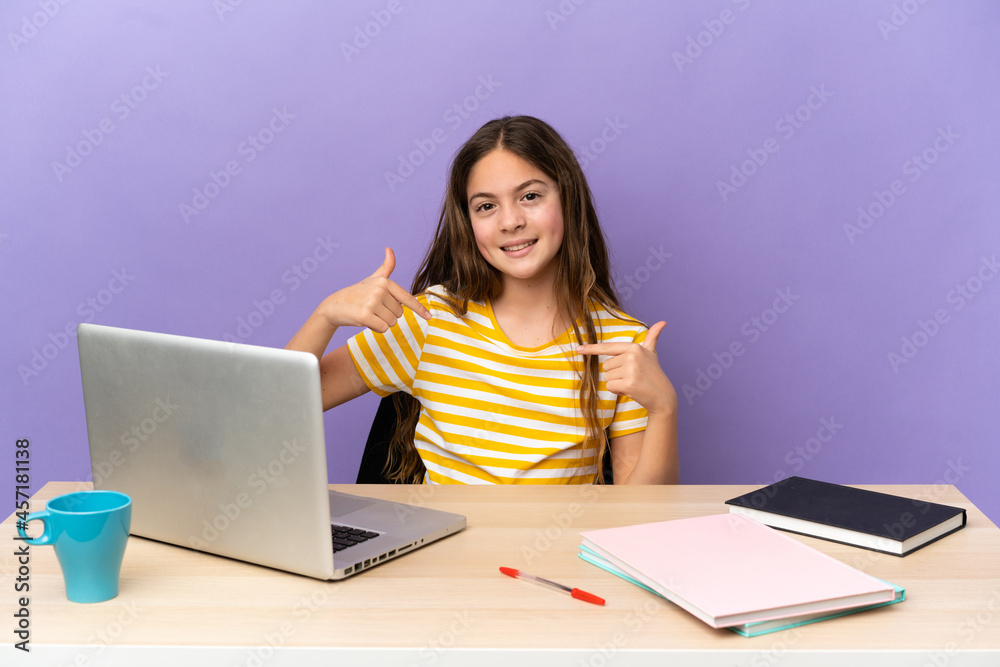 Little student girl in a workplace with a laptop isolated on purple background proud and self-satisfied Little student girl in a workplace with a laptop isolated on purple background proud and self-satisfied